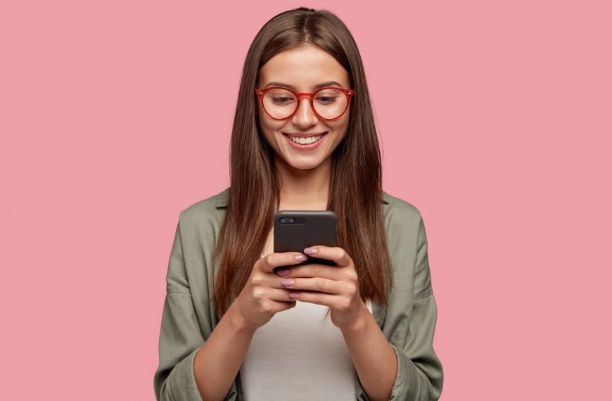 Satisfied lovely woman looking at the phone screen